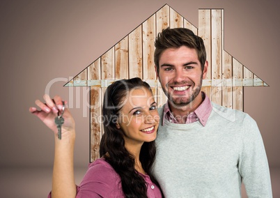 Couple Holding key with house wood icon in front of vignette