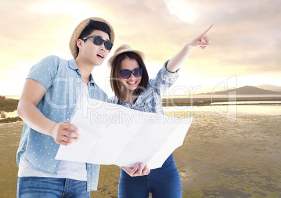 Couple with map against river and evening sky