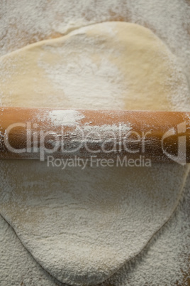 Overhead view of rolling pin on rolled dough