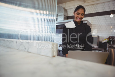 Waitress using laptop in cafe