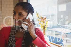 Woman talking on mobile phone in cafe
