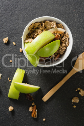 Bowl of breakfast cereals with fruits on black background