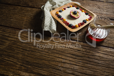 Fruit yogurt and honey on a wooden table