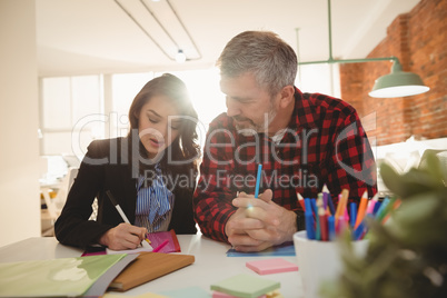 Business executives writing on sticky notes