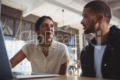 Couple with laptop looking each other in cafe