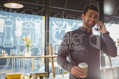 Businessman talking on phone in cafe