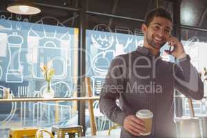 Businessman talking on phone in cafe