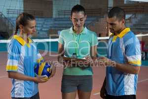 Coach discussing with volleyball players