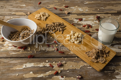 Breakfast cereals and milk on wooden table