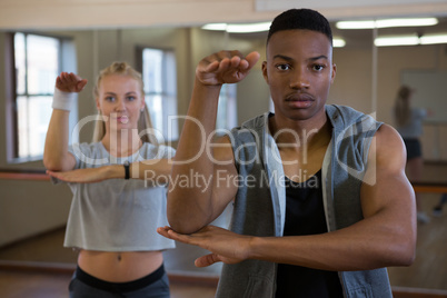 Portrait of male dancer with friend rehearsing