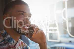 Young man talking on phone in cafe