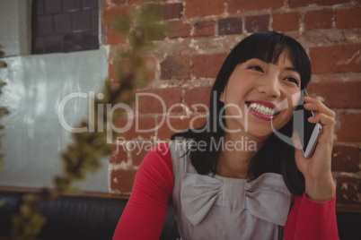 Woman talking on phone in cafe