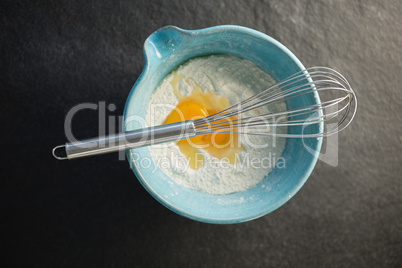 Overhead view of flour and egg in container