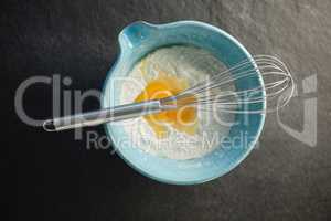Overhead view of flour and egg in container