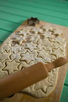 Close up star shape cookies on dough with rolling pin