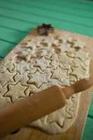 Close up star shape cookies on dough with rolling pin