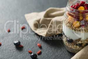 Yogurt with pomegranates and golden berries in glass jar