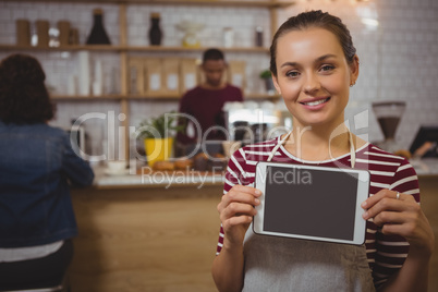 Portrait of female owner with tablet in cafe