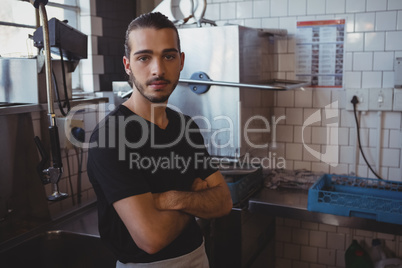 Portrait of waiter with arms crossed in kitchen