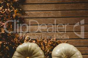 Autumn leaves by pumpkins on table during Halloween