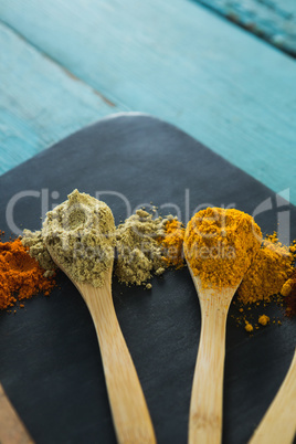 Various spice powder in wooden spoon