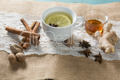 Ginger tea with honey and cinnamons on burlap