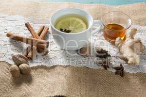 Ginger tea with honey and cinnamons on burlap