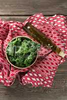 Fresh kale leaves with oil bottle and fabric on table