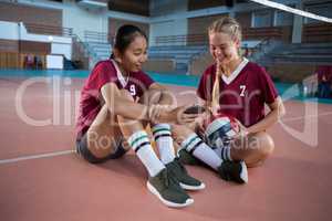 Smiling female players using mobile phone