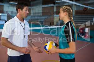 Male coach assisting volleyball player