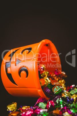 Orange bucket with colorful chocolates during Halloween