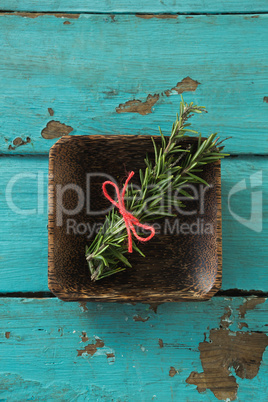 Tied rosemary in wooden bowl