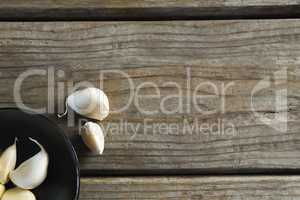 Garlics in plate on wooden table