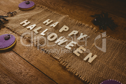 High angle view of happy Halloween text on sack with decorations