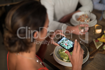 Woman taking photo of meal with mobile phone