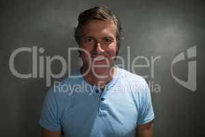 Portrait of happy man smiling against grey background