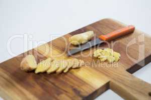 Close up of knife and chopped gingers on cutting board