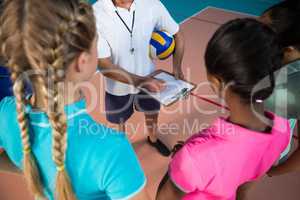 Volleyball coach talking to female players