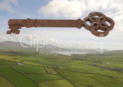 3D Rustic Key floating over green landscape