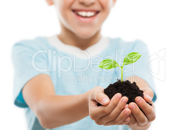 Handsome smiling child boy holding soil growing green sprout lea