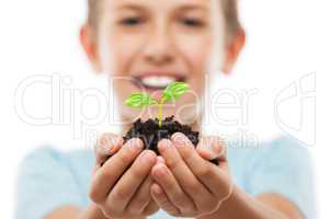 Handsome smiling child boy holding soil growing green sprout lea
