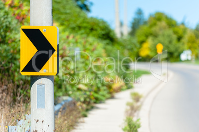 Chevron road sign indicating right turn.