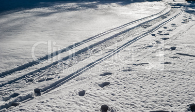 Snowmobile tracks and footprints on snow.