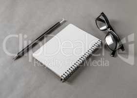 Notepad, glasses and pencil