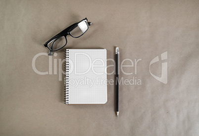 Notebook, glasses and pencil