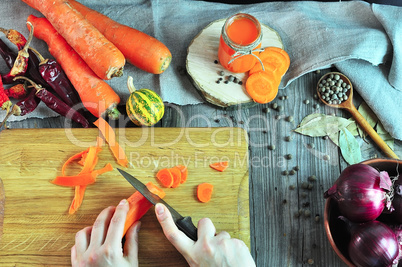 two female hands cutting a vegetable on a kitchen board