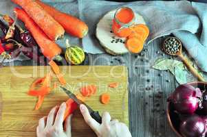 two female hands cutting a vegetable on a kitchen board