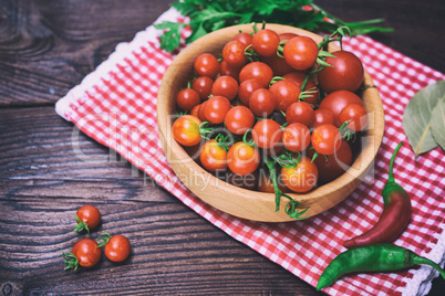 Ripe red cherry tomatoes in a wooden bowl