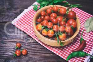 Ripe red cherry tomatoes in a wooden bowl