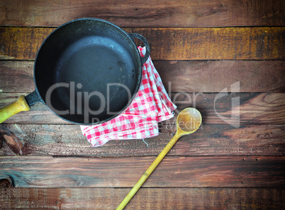 deep cast-iron frying pan with a wooden spoon, top view